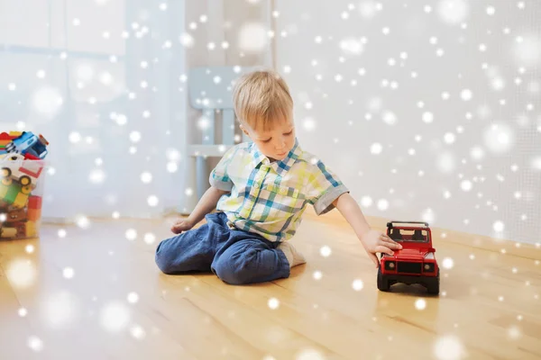 Menino pequeno brincando com carro de brinquedo em casa — Fotografia de Stock