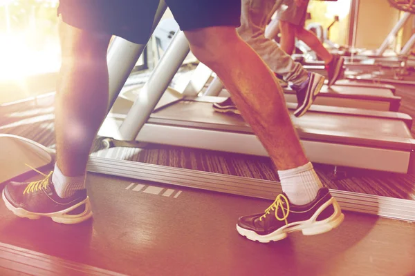 Närbild på män ben gå på löpband i gym — Stockfoto