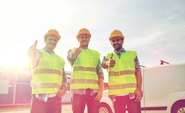 Constructores masculinos felices en chalecos altos visibles al aire libre — Foto de Stock