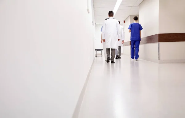 Группа медиков или врачей, идущих вдоль больницы — стоковое фото
