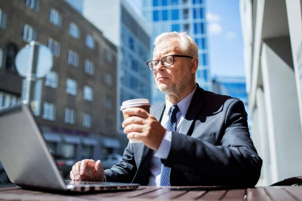 Senior businessman with laptop drinking coffee — Stock Photo, Image
