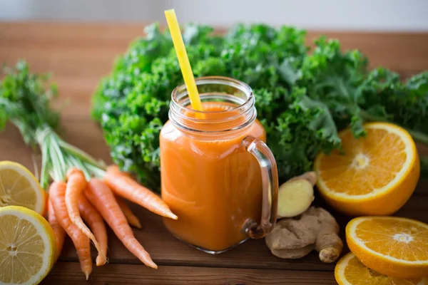 Glass jug of carrot juice, fruits and vegetables — Stock Photo, Image