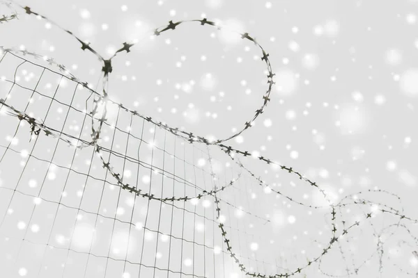 Barb wire staket över grå himmel och snö — Stockfoto