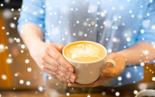 Close up de mãos com arte latte em xícara de café — Fotografia de Stock