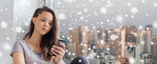 Sad pretty teenage girl with smartphone texting — Stock Photo, Image