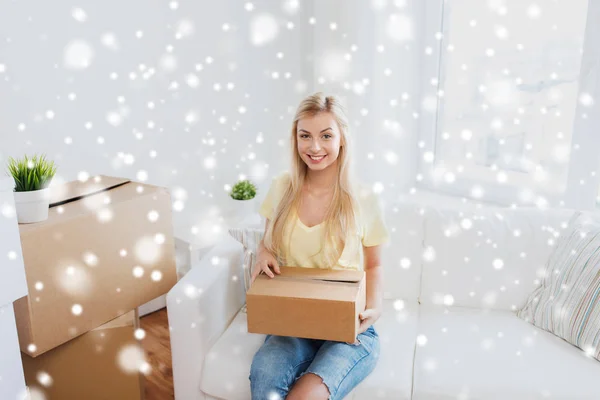 Karton kutu vasıl ev ile gülümseyen genç kadın — Stok fotoğraf