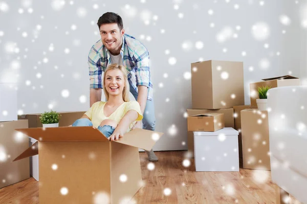 Happy couple having fun with boxes at new home — Stock Photo, Image