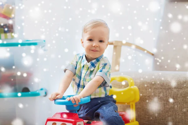 Pequeño bebé feliz conduciendo coche de paseo en casa —  Fotos de Stock