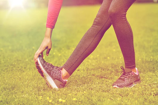 Primer plano de la mujer que estira la pierna al aire libre — Foto de Stock