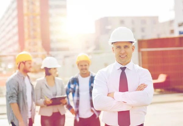 Mosolygó építők, szabadban hardhats csoportja — Stock Fotó