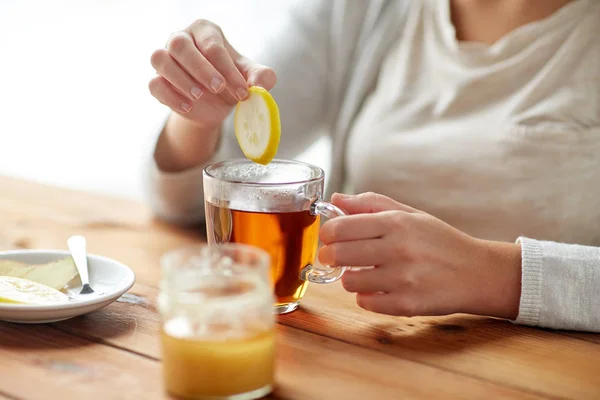 Close up of ill woman drinking tea with lemon — Stock Photo, Image