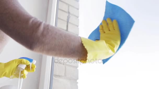 Женщина в перчатках моет окно тряпкой — стоковое видео