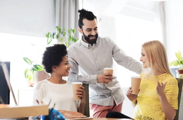 Equipo de negocios con tazas de café hablando en la oficina —  Fotos de Stock