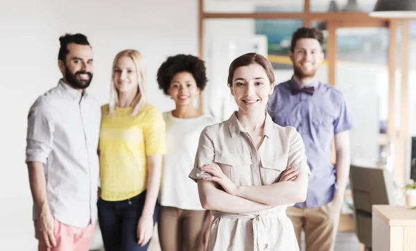 Feliz joven mujer sobre creativo equipo en la oficina — Foto de Stock