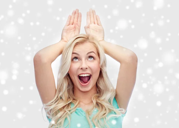 Happy smiling young woman making bunny ears — Stock Photo, Image