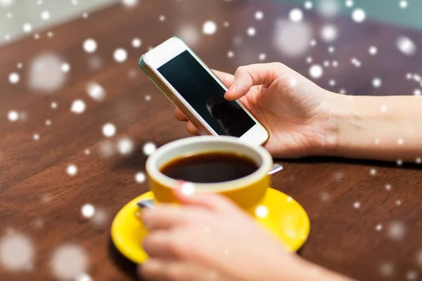 Женщина со смартфоном пьет кофе в кафе — стоковое фото