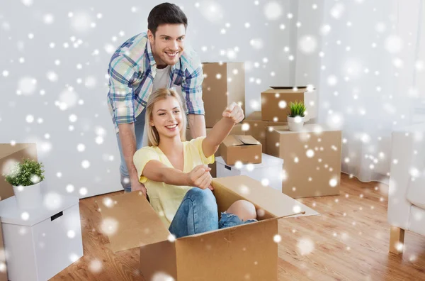 Happy couple having fun with boxes at new home — Stock Photo, Image