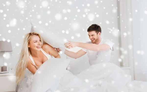 Lyckliga par att ha kudde slåss i sängen hemma — Stockfoto