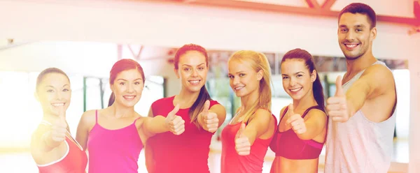 Groupe de personnes dans la salle de gym montrant pouces vers le haut — Photo