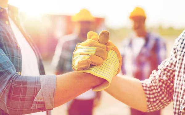 Close-up de construtores mãos fazendo aperto de mão — Fotografia de Stock