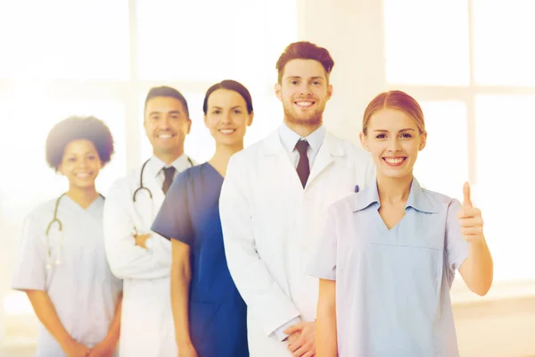 Medici felici mostrando pollici in alto in ospedale — Foto Stock