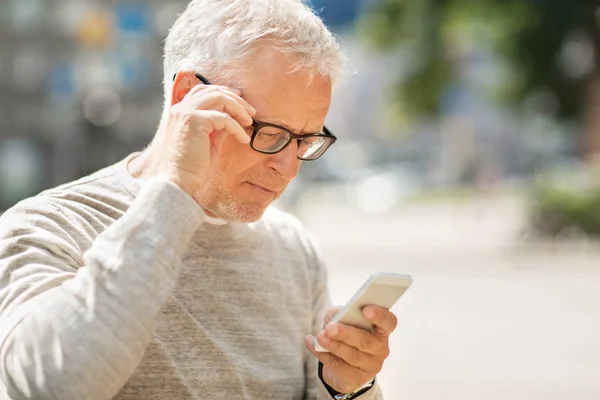 Homem sênior mensagem de texto no smartphone na cidade — Fotografia de Stock