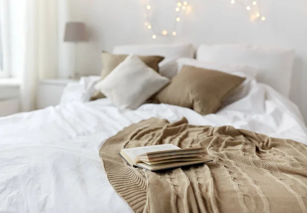 Dormitorio con cama y guirnalda de Navidad en casa —  Fotos de Stock