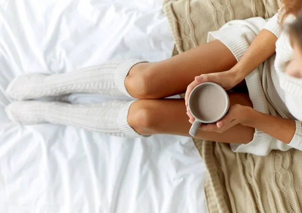 Primer plano de la mujer con taza de cacao en la cama en casa —  Fotos de Stock
