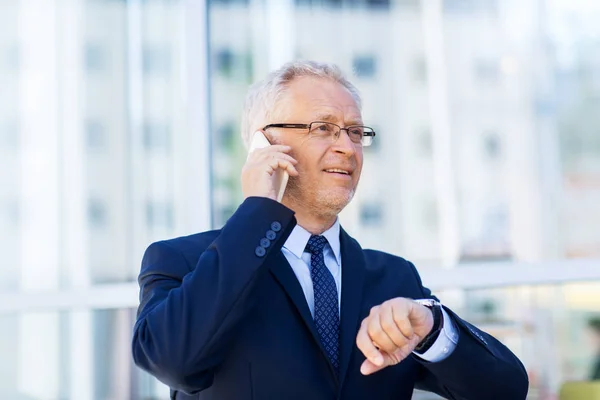 Senior affärsman ringer på smartphone i staden — Stockfoto