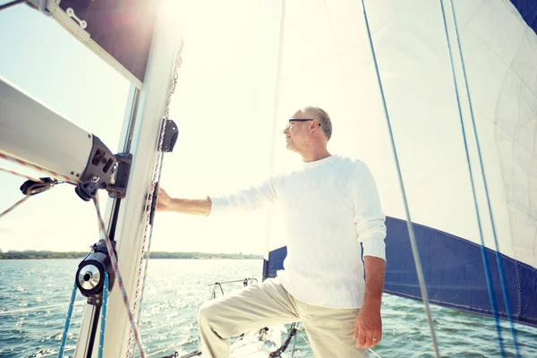 Senior Mann auf Segelboot oder Jacht, die im Meer segelt — Stockfoto