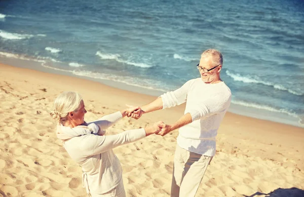 Gelukkige senior paar bedrijf handen op zomer strand — Stockfoto