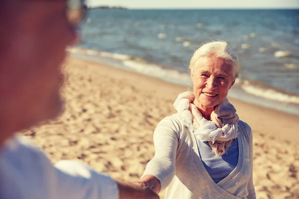 快乐的年长夫妇手牵着手夏天海滩 — 图库照片