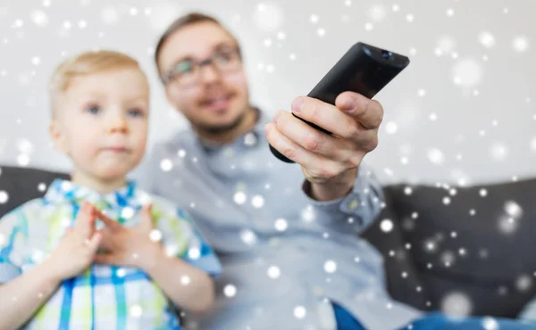 Pai e filho com controle remoto assistindo tv em casa — Fotografia de Stock