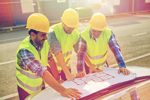 Close up of builders with blueprint on car hood — Stock Photo, Image