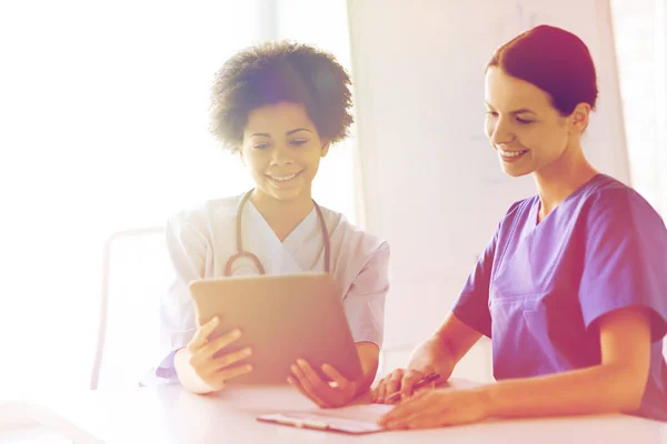 Happy doctors with tablet pc meeting at hospital — Stock Photo, Image