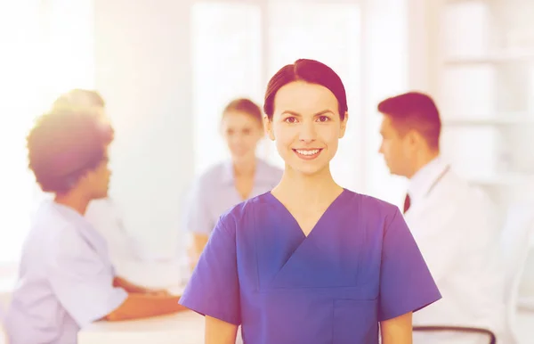 Gelukkig arts over groep van dokters in ziekenhuis — Stockfoto