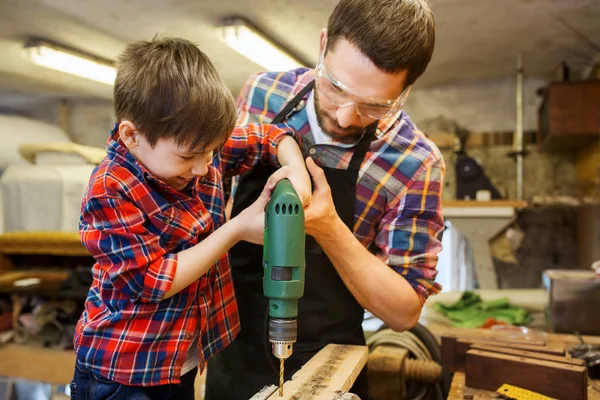 Father and son with drill working at workshop — Stock Photo, Image