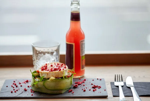 Salada, garrafa de bebida, vidro e talheres na mesa — Fotografia de Stock