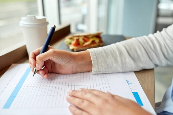 Kvinna med pappersformulär med lunch på café — Stockfoto