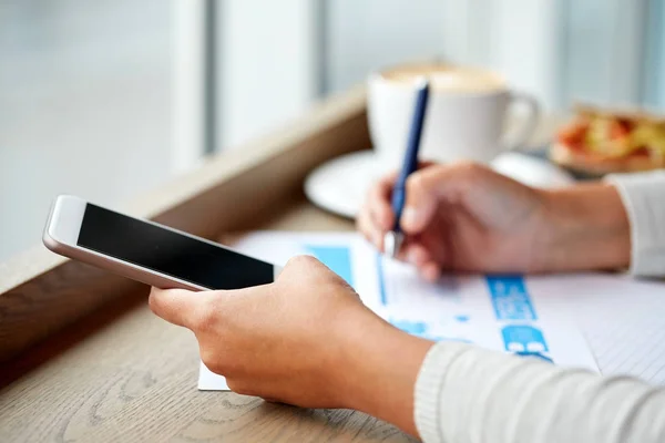 Donna con smartphone e grafico al caffè — Foto Stock