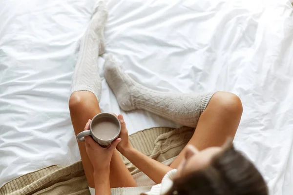 Primer plano de la mujer con taza de cacao en la cama en casa — Foto de Stock