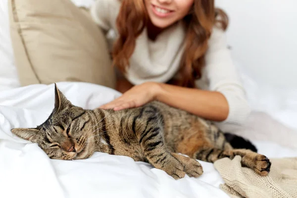 Ευτυχισμένη γυναίκα με γάτα ξαπλωμένη στο κρεβάτι στο σπίτι — Φωτογραφία Αρχείου
