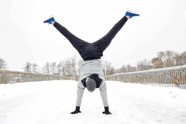 Junger Mann macht Handstand im Winter — Stockfoto