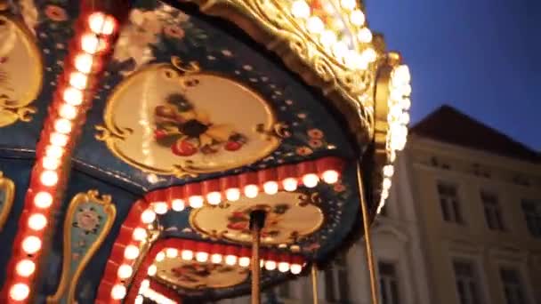 Carrusel iluminado en la ciudad vieja por la noche — Vídeos de Stock
