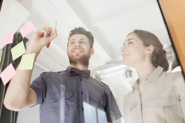 Feliz equipo creativo escribiendo en vidrio de oficina en blanco — Foto de Stock