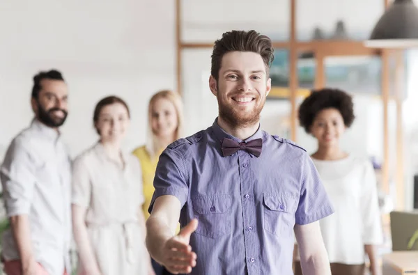 Feliz hombre haciendo apretón de manos sobre el equipo de oficina — Foto de Stock