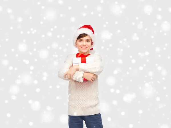 微笑快乐的男孩，在圣诞老人的帽子与礼品盒 — 图库照片