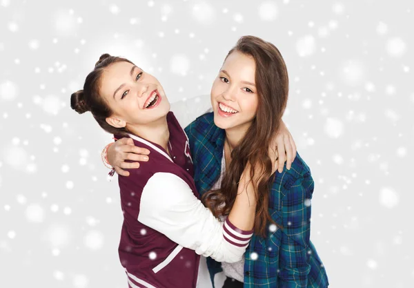 Счастливые улыбающиеся девочки-подростки, обнимающиеся по снегу — стоковое фото