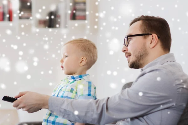 Vader en zoon met externe tv kijken thuis — Stockfoto