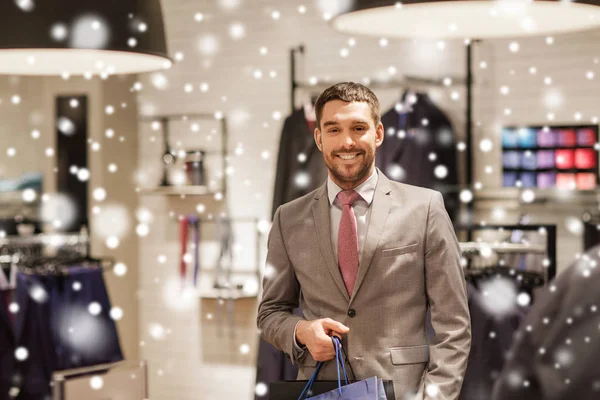 Glücklicher Mann mit Einkaufstaschen im Bekleidungsgeschäft — Stockfoto